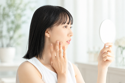 お肌を気にして鏡を見る女性